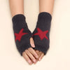 A pair of dark gray knitted half finger gloves with a red star pattern on the palms.