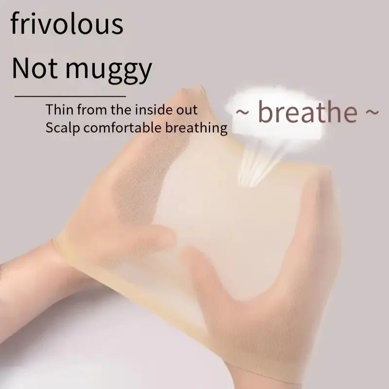 A hand is holding a sheer, light beige wig cap or hair netting against a light gray background.