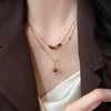 Gold-toned necklace featuring a tiger eye sunflower pendant worn against a brown blazer.