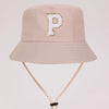 A light beige sun hat with a gold letter P embroidered on the front and a light tan strap.