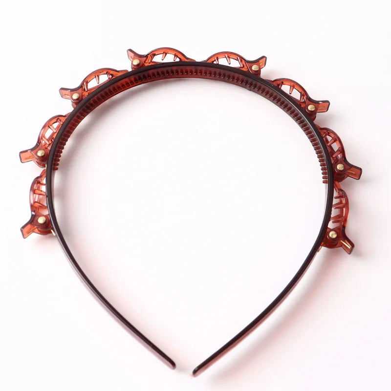 An orange braided hair headband clip with decorative elements, shown against a white background.
