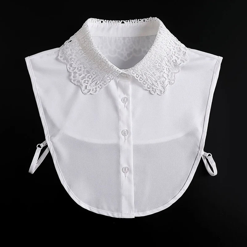 White blouse with a lace false collar and detachable neckline, shown against a black background.