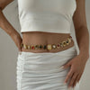 A woman wearing a white top and skirt displays a boho gold plated resin statement choker necklace.