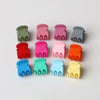 A set of eight adjustable hair claw clips in various pastel and muted colors, including green, pink, gray, orange, blue, and 