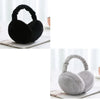A pair of black plush fur ear warmers or earmuffs resting on a white surface.