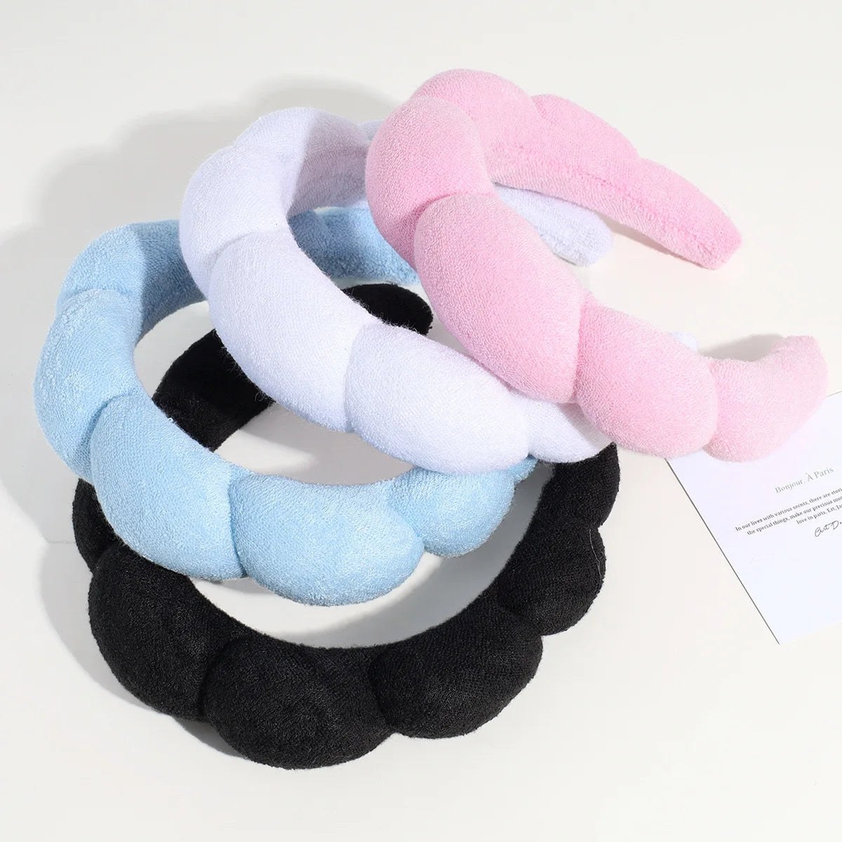 Un pack de trois bandeaux pour la tête et les poignets élégants en rose, blanc et bleu.