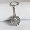 Silver round medallion keychain featuring a depiction of St. Benedict.