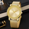 A gold-toned men's quartz wristwatch with a round face and slim mesh strap resting on a dark surface.