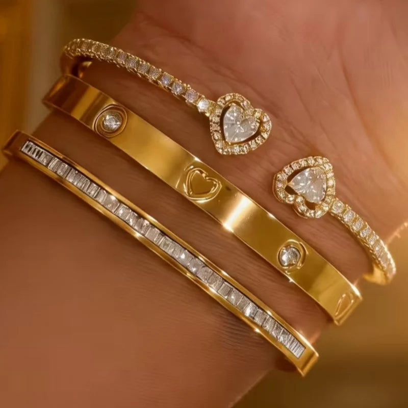 Ein Set aus 18K vergoldetem Edelstahl-Herzarmbändern, getragen am Handgelenk.