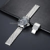A silver stainless steel watch with a metal link bracelet and a square-shaped watch case is displayed on a dark surface.