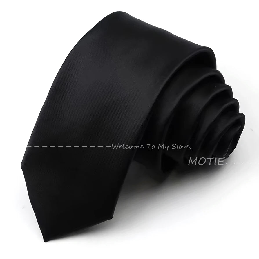 A black satin neck tie is shown folded and draped on a white background.