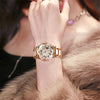 Primer plano de una mano femenina vistiendo un elegante reloj de pulsera de diamantes de cuarzo dorado.