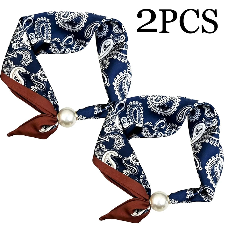 Two navy blue paisley scarf pieces with brown trim and pearl magnetic clasps
