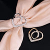 Gold and silver rhinestone decorative button clips resting on a soft peach silk fabric.