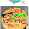 A collection of colorful square frame costume glasses displayed on a wooden table.