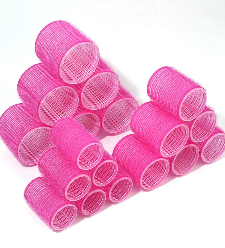 A pile of bright pink heatless hair curlers for DIY styling tools.
