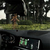 Interior view of a car dashboard showing a digital display and a hanging protection charm set.