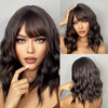 A close-up photo of a woman modeling a short wavy bob wig in dark brown hair