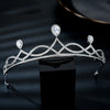 Diadème de mariée argenté orné de diamants taillés, présenté sur un socle noir.