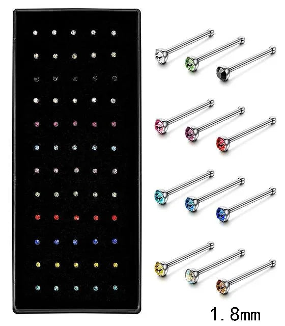 A set of stainless steel nose studs and body piercing jewelry in various sizes and colors.