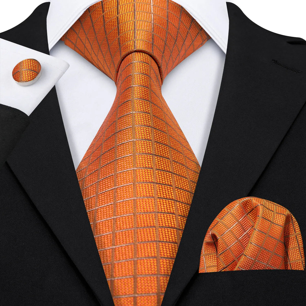 A close-up of a men's silk jacquard tie in orange and gold tones worn with a black suit jacket.
