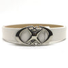 Silver moon star buckle on a white leather belt.