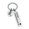 Silver keychain with a circular charm featuring the letter R and a tag that reads Drive Safe I need you here with me