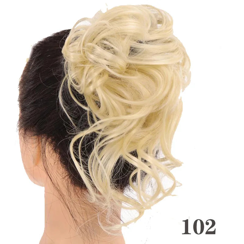 A woman's dark hair is styled into a messy blonde bun with loose, wavy strands.