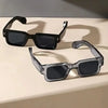 Eine schwarze, quadratische Sonnenbrille liegt auf einer hellen Oberfläche.