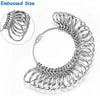 A silver metal ring sizer tool kit showing various rings and a mandrel tool for sizing jewelry.