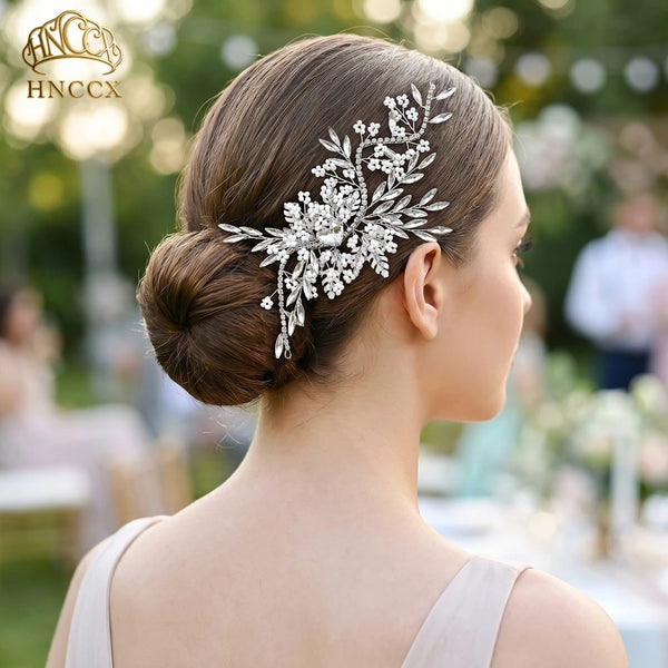 A close-up profile of a woman wearing a delicate rhinestone bridal headband with floral accents.