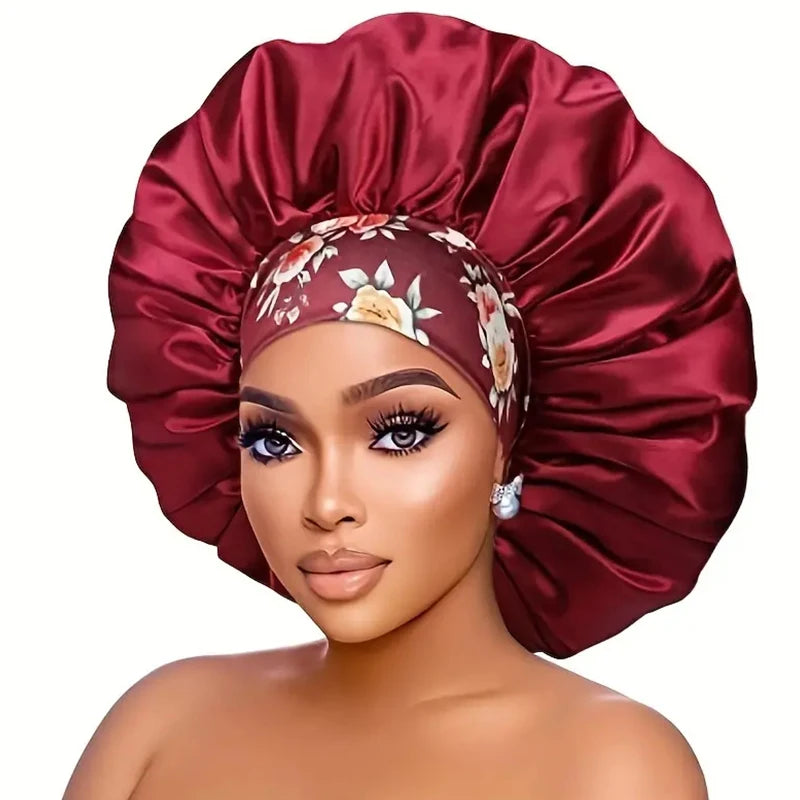 A model is wearing a deep red satin sleep bonnet with an elastic band on her head.