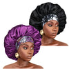 A model wears a purple satin sleep bonnet with an elastic band and gold earrings.