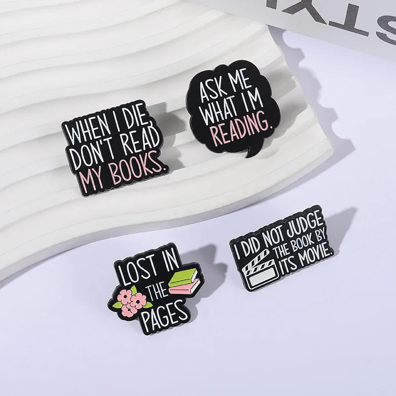 Black enamel lapel pins featuring literary quotes like When I Die Don't Read My Books and I Did Not Judge The Book By Its Mov