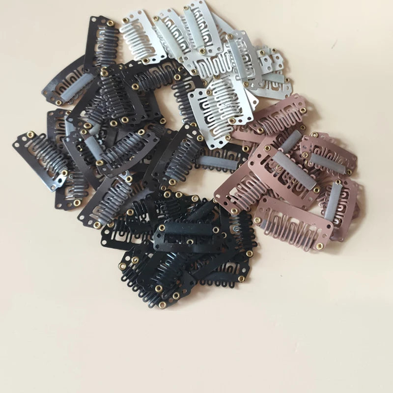 A collection of precision hair extension clips in various shades of black, silver, and pink.