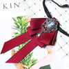 A deep red velvet bow tie with silver rhinestone embellishments and a black ribbon, shown against a white background.