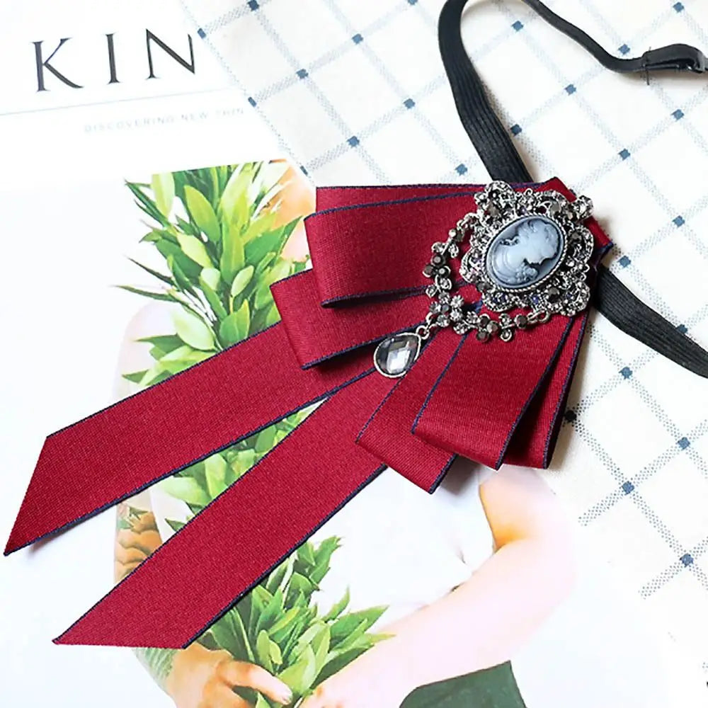 A deep red velvet bow tie with silver rhinestone embellishments and a black ribbon, shown against a white background.