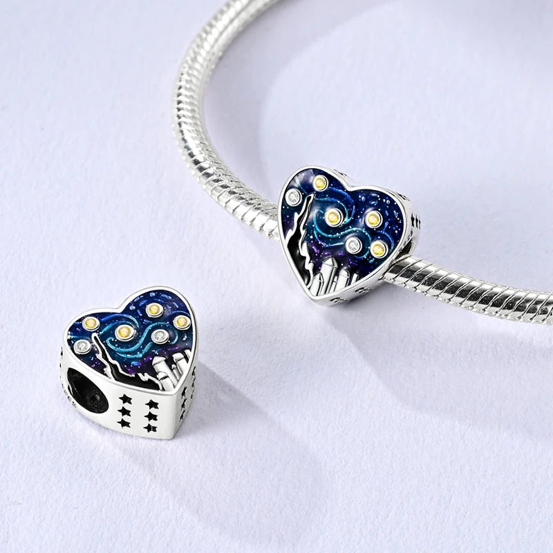 Sterling silver devil's eye charm bracelet featuring a heart pendant with blue and gold eye motifs