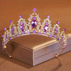 Diadema de cristal brillante con piedras moradas y claras, mostrada sobre una caja neutra.