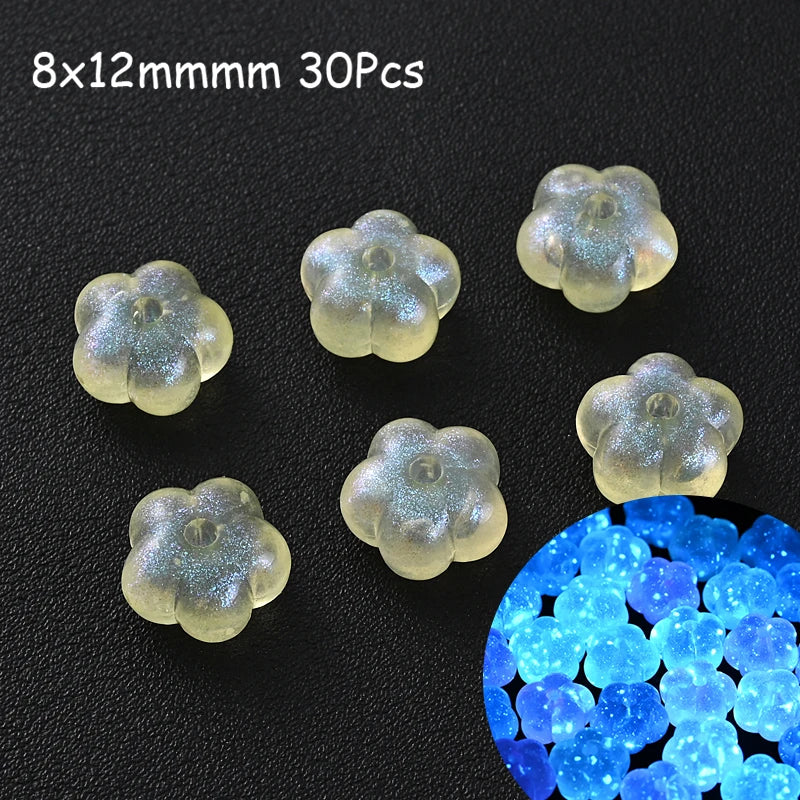 A collection of luminous glow-in-the-dark acrylic beads in various shapes and sizes scattered on a dark surface.