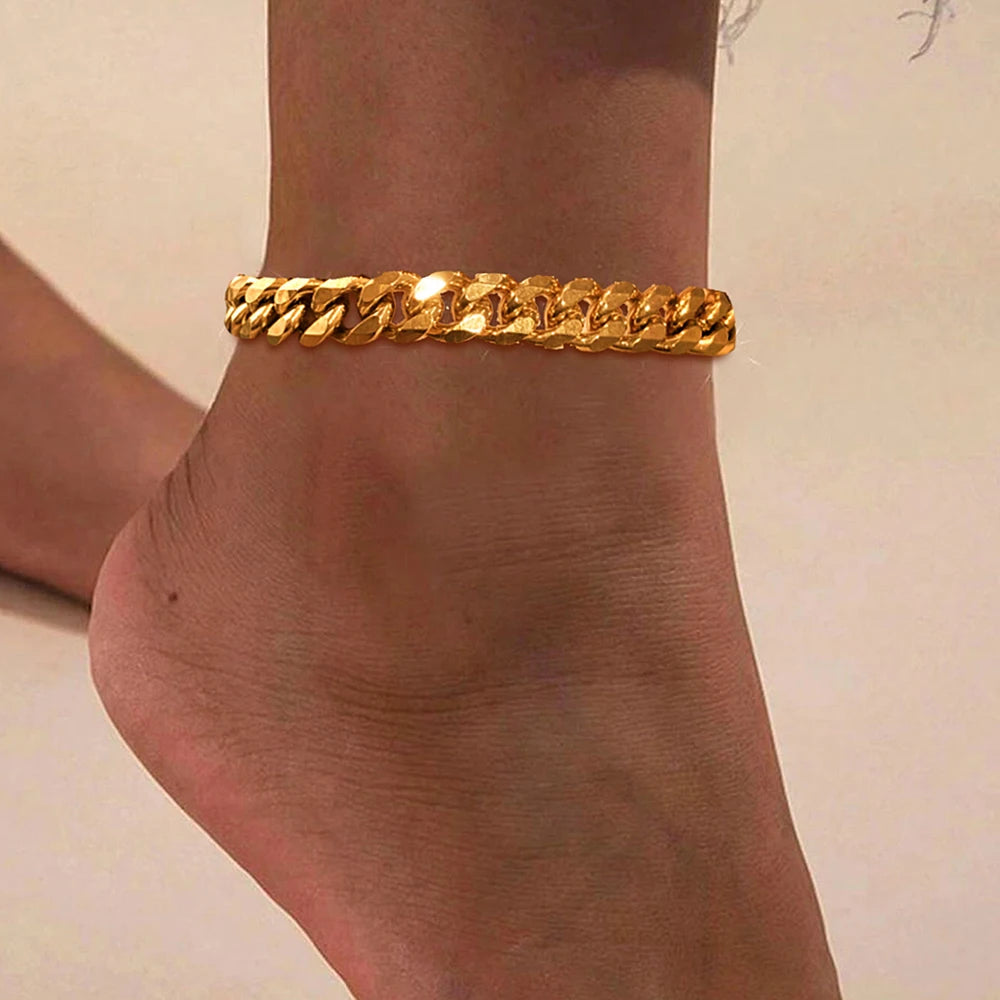 A close-up of a gold-colored multi-chain stainless steel anklet worn on a person's ankle.