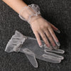 Clear lace tulle finger gloves worn on a hand against a dark gray fabric background.