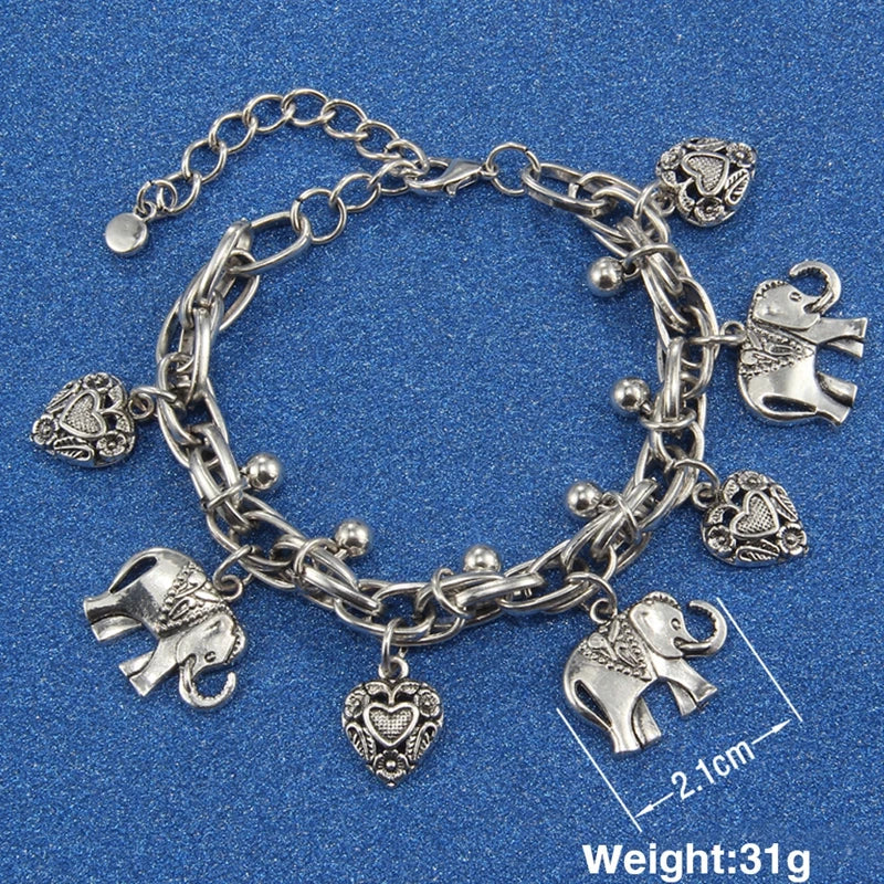 Silver chain bracelet with elephant charms and a heart pendant on a blue background