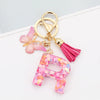Alphabet letter acrylic keychain shaped like a letter with pink butterfly and a pink tassel