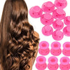A set of pink heatless magic hair curlers shown next to long brown hair.
