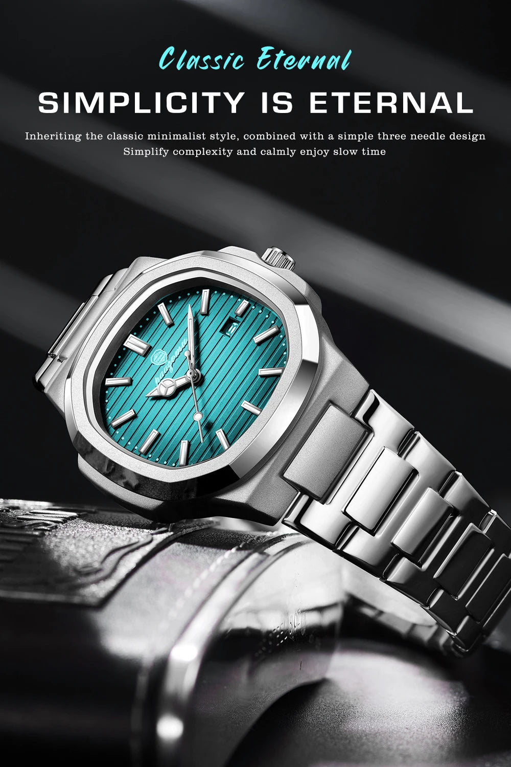 A silver-toned watch with a turquoise dial and blue accents is shown on a wrist, highlighting its classic design.