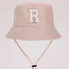 A light beige sun hat with a large white letter R embroidered on the front.