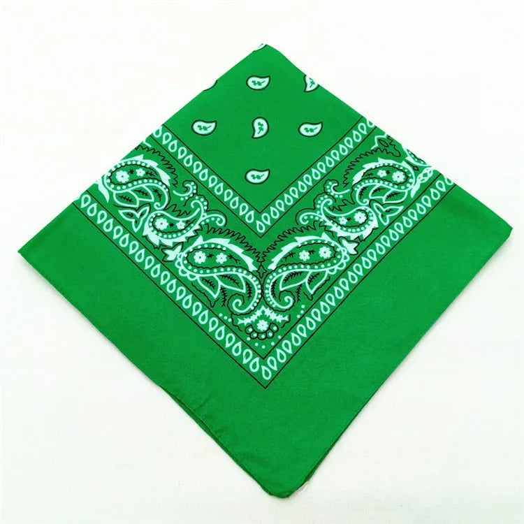 A bright green paisley bandana fabric with white embroidery and geometric patterns.
