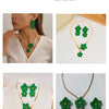 Gold-toned floral pendant necklace and matching earrings set with green leaves
