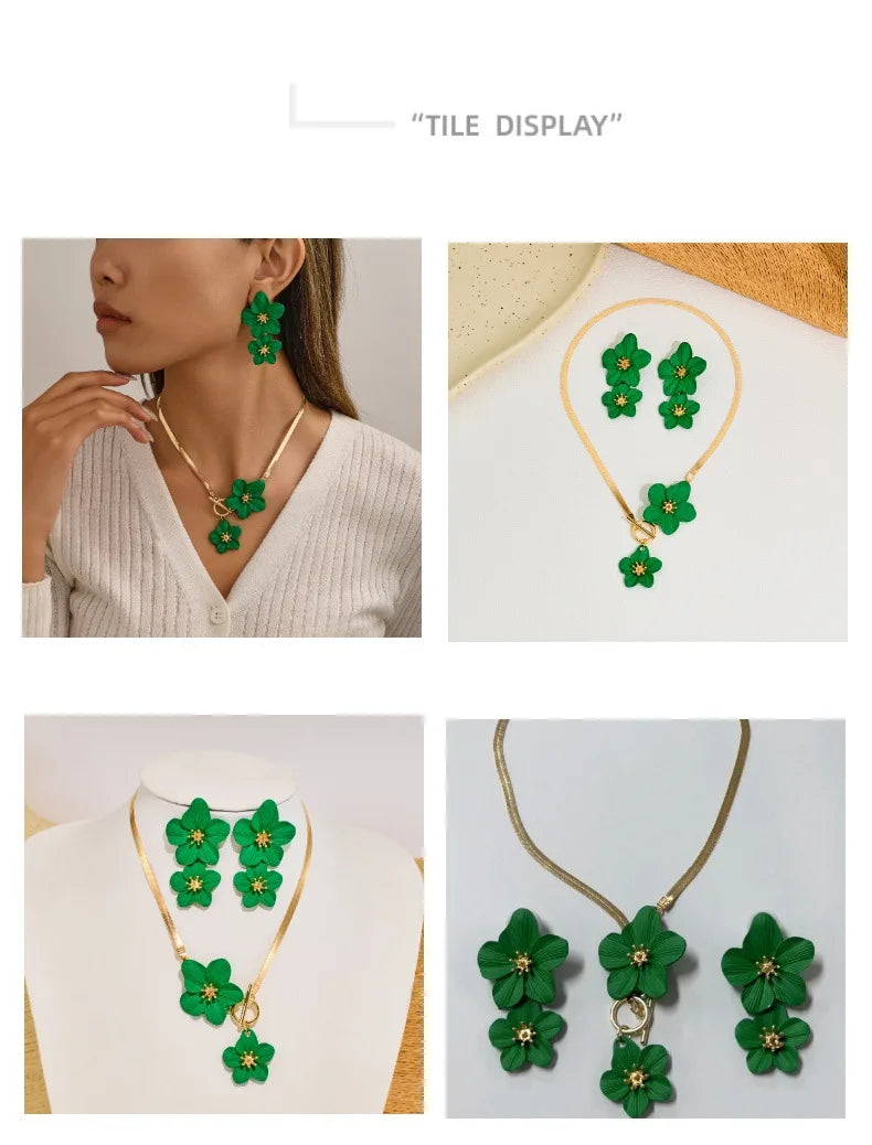 Gold-toned floral pendant necklace and matching earrings set with green leaves